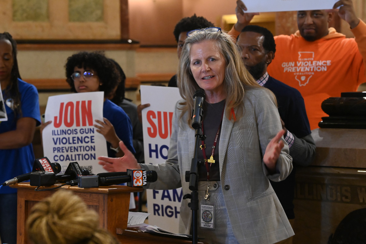 State Senator Laura Ellman speaking at podium at a rally
